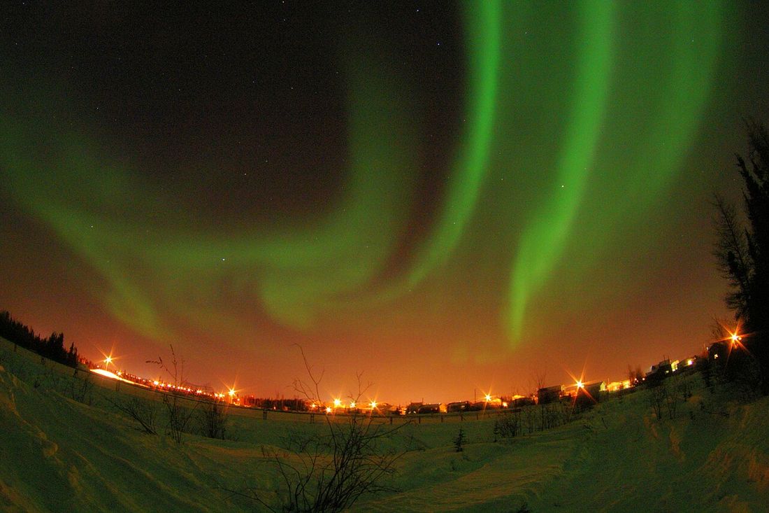 Aurora boreal sobre las luces de Yellowknife, Canadá